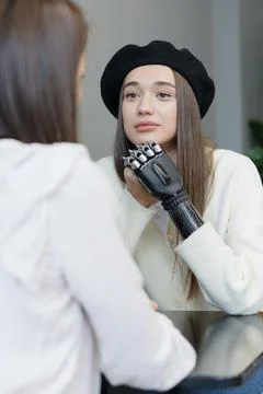 A European woman with a bionic prosthesis on her arm is talking to friends in a Stock Photos