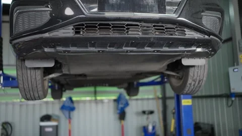 EV Car hangs suspended in workshop bay 库存影片 339050455
