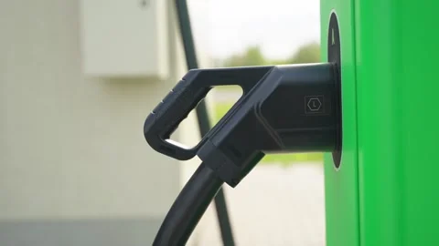 EV Charging Plug on Modern Green Station Closeup Stockbeeldmateriaal 335291528