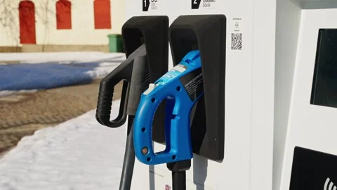 EV charging station plugs mounted on charger with snow on ground Stockbeeldmateriaal 333044404