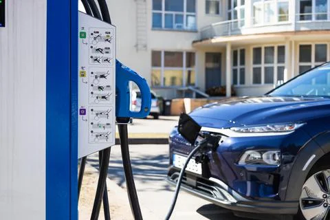 EV charging station with the power cable supply plugged in an electric car Stock Photos