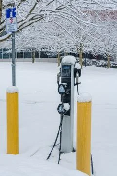 EV charging station for zero emission cars on white snow background Stock Photos