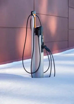 EV charging station for zero emission cars in white snow pile Stock Photos