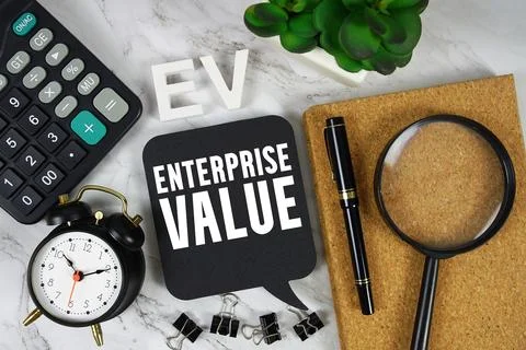 EV Enterprise Value text with Calculator, alarm clock and magnifying glass .. Stock Photos