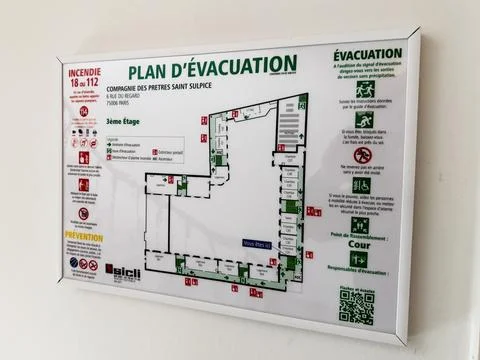 Evacuation plan sign with floor map and safety instructions mounted on wall.. Foto stock