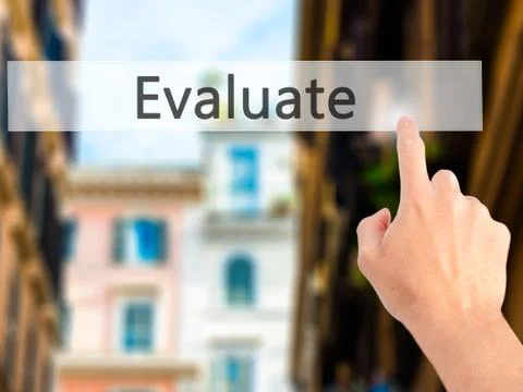 Evaluate - Hand pressing a button on blurred background concept . Business, t Stock Photos
