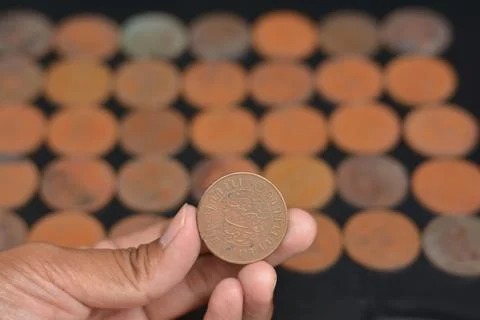 Evaluating an Antique Coin with Arabic Script Against a Dark Grid Background Stock Photos