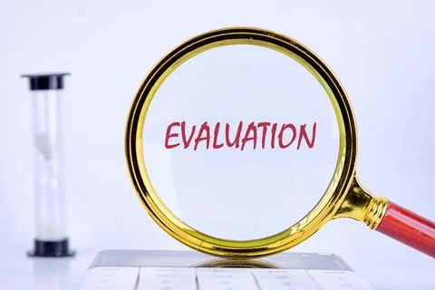 EVALUATION text was revealed through a magnifying glass on a light background Stock Photos