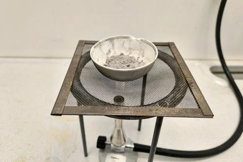 Evaporation of a ceramic dish containing silver granules Stock Photos