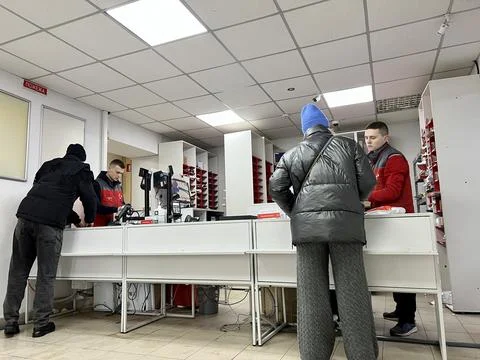 Even during war parcel delivery works People come to counter to receive or send Stock Photos