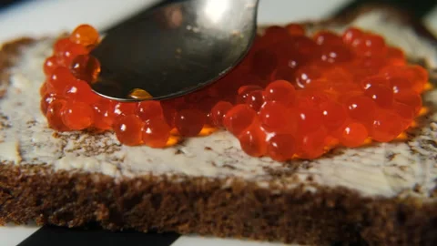 Even layer of red caviar on rye slice Stock Footage 321954866