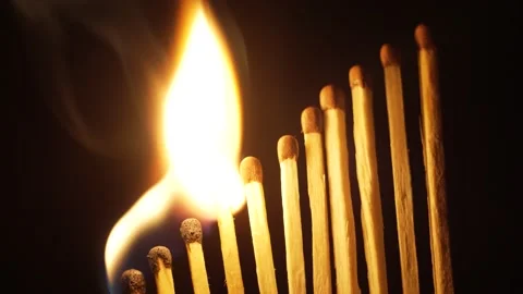 An even row of matches lined up by a ladder alternately lights up on a dark Video stock 166473920