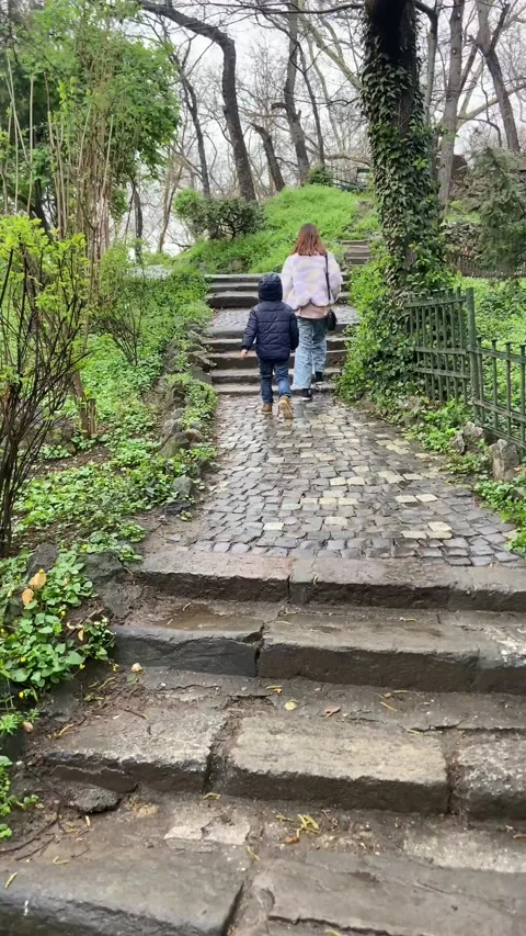 Even when it is raining, children like to roam the paths of the park. Stock Footage 237723581