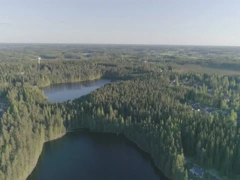 Evening aerial view of 2 lakes in dense forest and residential homes Stock Footage 76818002
