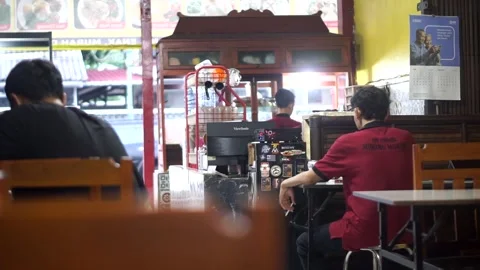 Evening atmosphere inside a Padang restaurant with customers dining Stock Footage 343578752