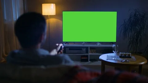  In the Evening Back View of a Middle Aged Man Sitting on a Couch Watching TV Stock Footage 72523309