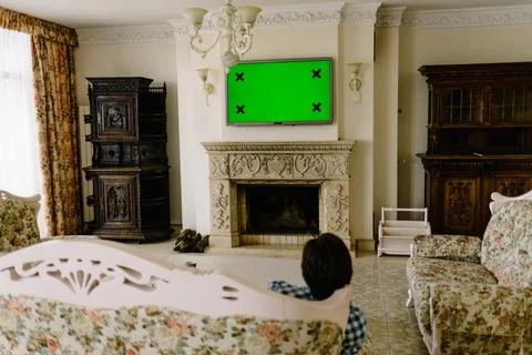 In the Evening Back View of a Middle Aged Man Sitting on a Couch Watching B.. Stock Photos