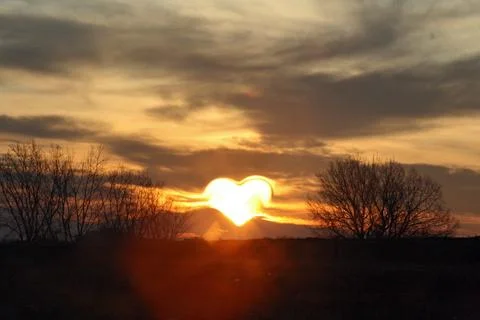 Evening background, heart shaped sun Stock Photos