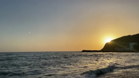 Evening beach against the backdrop of an orange sunset cloudy sky Stock Footage 238809675