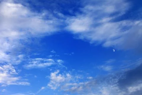 Evening blue sky with clouds and moon Stock Photos