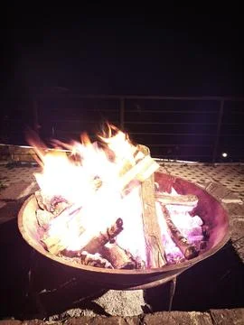 Evening Bonfire Flames in a Fire Pit With Railing Behind Stock Photos