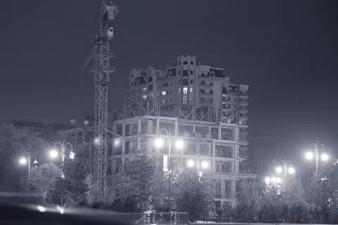 In the evening building is going to be built. Silhouette Building crane and b Stock Photos