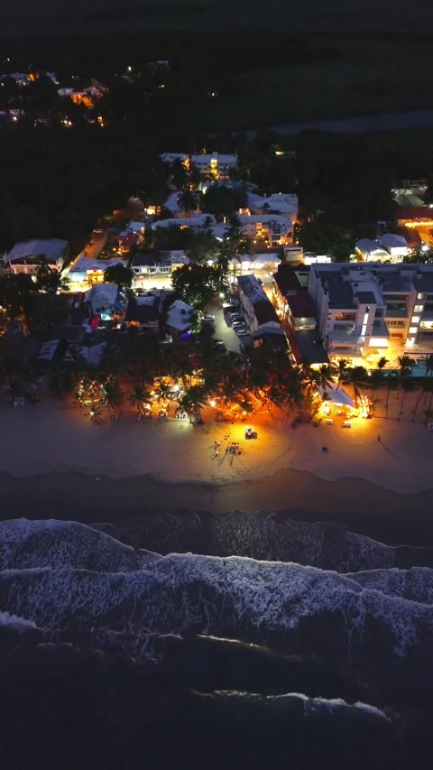 Evening Cabarete Beach with Palm Trees and Illuminated Restaurants. Aerial View Stock Footage 314866594