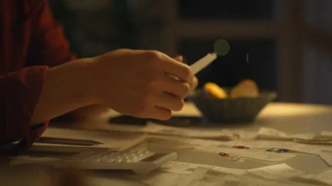 Evening calculations and planning with calculator and notes in a cozy settin Stock Footage 303662578