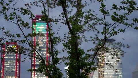 Evening cityscape featuring illuminated office buildings with vibrant lights Video stock 310347783