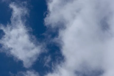 Evening clouds on the background of the blue sky. Stock Photos
