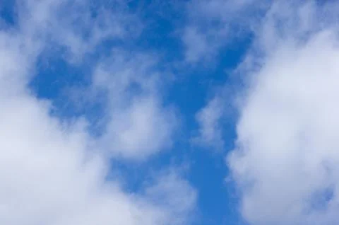 Evening clouds on the background of the blue sky. Stock Photos