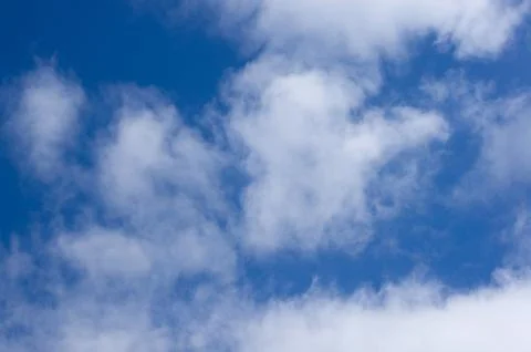 Evening clouds on the background of the blue sky. Stock Photos