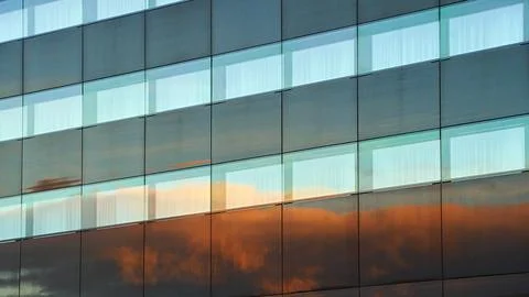 Evening clouds reflected in the modern building windows in a city background Stock Photos
