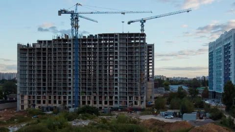 Evening construction site with cranes building apartment block in autumn Stock Footage 318541402