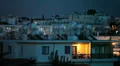 Evening in the Cypriot town with man sitting on balcony with light in dark HD Footage