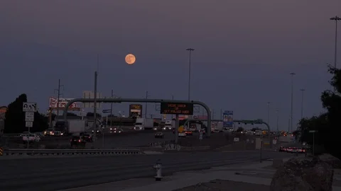 Evening darkens full moon rises over busy Interstate 10-Time Lapse Video stock 77650129