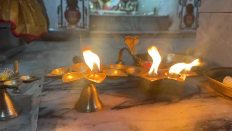 Evening Diya Burning Inside Hindu Temple with Blurred Shrine Background Stock Footage 339264362