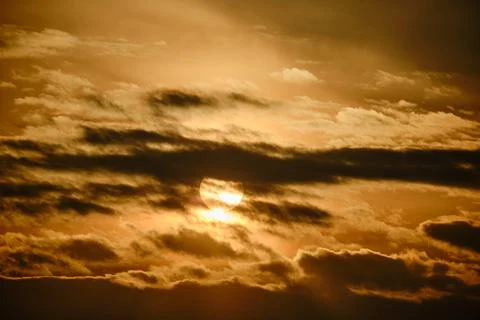 Evening dramatic sky with clouds during sunset. The sun sets behind dark clou Stock Photos