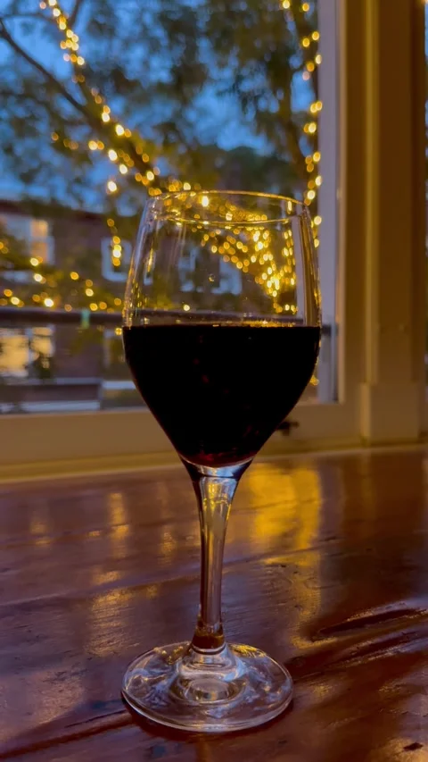 Evening drink by the window with warm lights Stock Footage 341292976