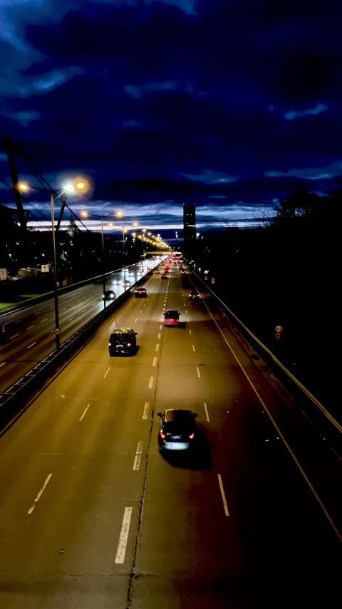 Evening Drive Along a Busy Highway With City Lights and a Dramatic Sky Stock Footage 301136790
