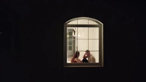 Evening drone view of a loving couple sitting by the window of the villa Stock Footage 229954084