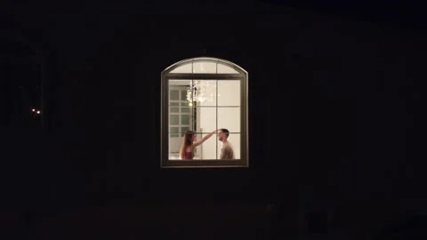 Evening drone view of a loving couple sitting by the window of the villa Stock Footage 229955289