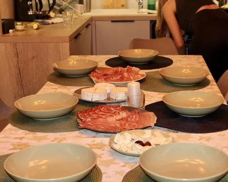 In the evening, a festive table is set in the semi-lit kitchen room Stock Photos