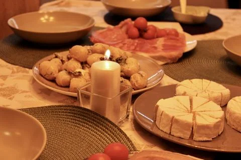 In the evening, a festive table is set in the semi-lit kitchen room Stock Photos