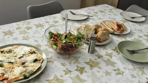 In the evening, a festive table is set in the semi-lit kitchen room Stock Photos