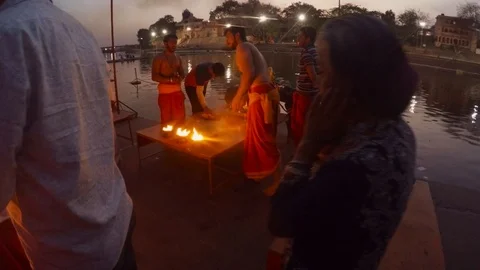 Evening flames after hindu ceremony priest and people on bank of sacred river Sh Stock Footage 106277481