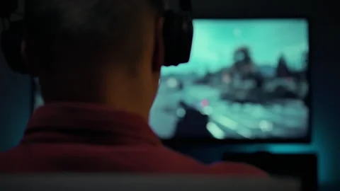 Evening gaming session with male player focused on action on the screen Stock Footage 323767176