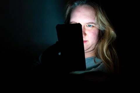 Evening glow of a mother engaging with her smartphone in a quiet room Stock Photos