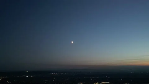 Evening Halfmoon over the city zoom-in Stock Footage 219565548