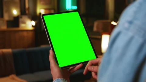 In the evening hands holding scrolling tablet computer with a vertical green Stock Footage 238745187